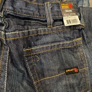 Dark blue men’s Ariat low-rise, boot cut M4 flame resistant work jeans. 33/34
